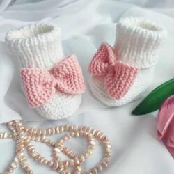 Białe buciki dla niemowląt z różową kokardką